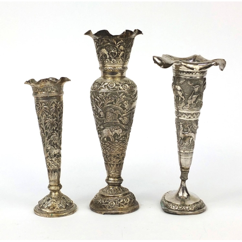 597 - Three Indian unmarked silver vases, each embossed with animals amongst trees and with frilled rims, ... 