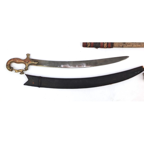 655 - Four Middle Eastern swords including two African with part leather sheaths and an Indian short sword... 