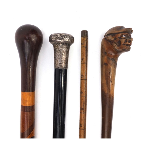 163 - Four wooden walking sticks including an ebonised silver topped example, one carved with a face and a... 