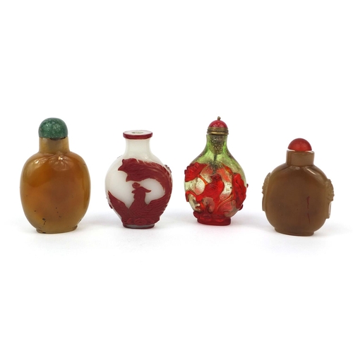 523 - Four Chinese snuff bottles comprising two cameo examples, one decorated with a dragon the other with... 