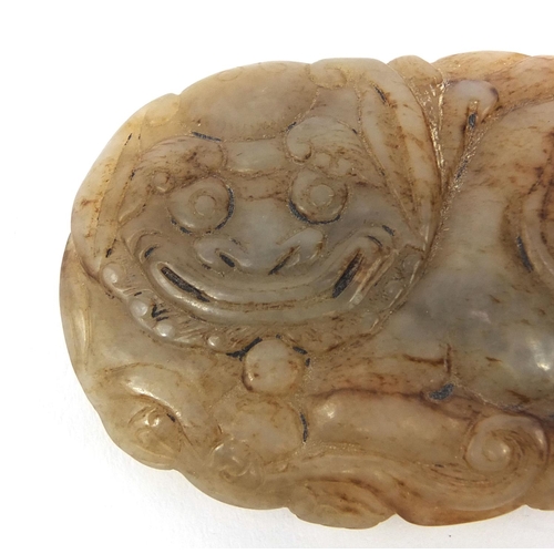 512 - Chinese russet coloured jade buckle, carved in the form of a Dog of Foo, 7cm wide