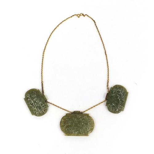 607 - Three Islamic green nephrite panels on a gold coloured metal necklace, the panels carved with script... 