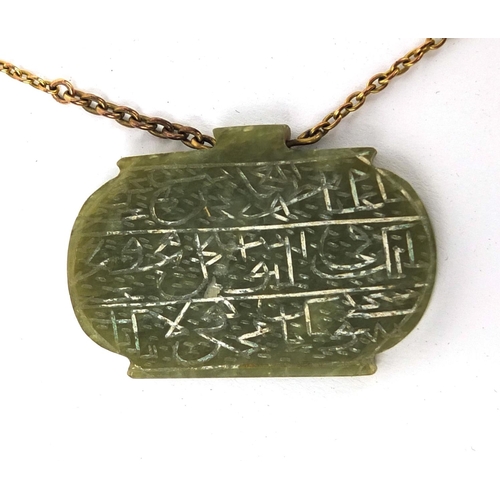 607 - Three Islamic green nephrite panels on a gold coloured metal necklace, the panels carved with script... 