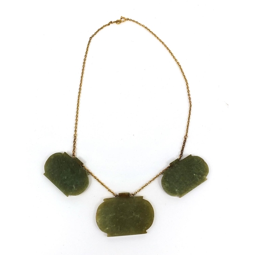 607 - Three Islamic green nephrite panels on a gold coloured metal necklace, the panels carved with script... 