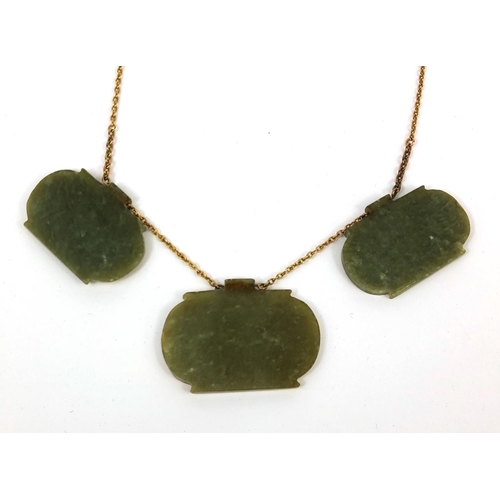 607 - Three Islamic green nephrite panels on a gold coloured metal necklace, the panels carved with script... 