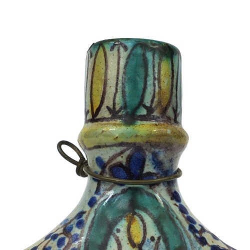 619 - Islamic iznik pottery flask with twin handles, hand painted with stylised flowers, 24cm high