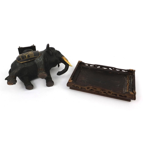 555 - Japanese bronze elephant with ivory tusks and Egyptian design seat, raised on a hardwood base, the e... 