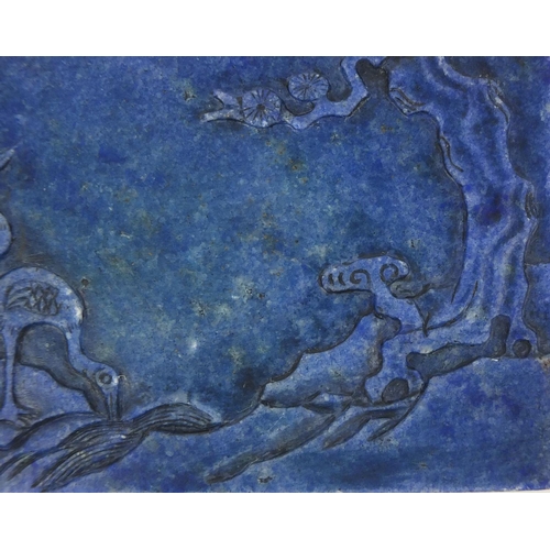 525 - Chinese Lapis Lazuli panel raised on a pierced hardwood stand, the panel carved with two cranes besi... 