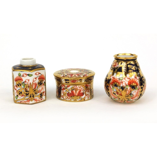 693A - Three miniature Royal Crown Derby Imari pattern items comprising a vase, cylindrical pot and cover a... 