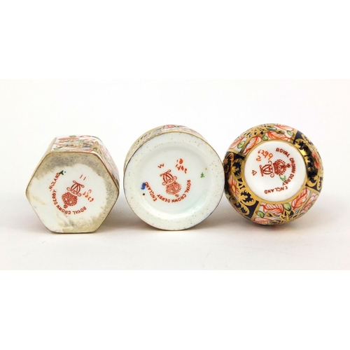 693A - Three miniature Royal Crown Derby Imari pattern items comprising a vase, cylindrical pot and cover a... 