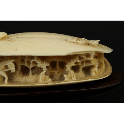 534 - Chinese ivory clam shell, the interior carved with a figure on horseback in a landscape, raised on a... 