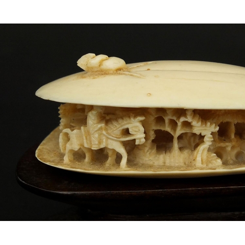 534 - Chinese ivory clam shell, the interior carved with a figure on horseback in a landscape, raised on a... 