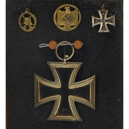 356 - German Military interest iron cross, two pendants and stick pin, all housed in a glazed case