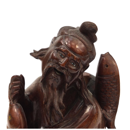 543 - Chinese hardwood root carving of a fisherman holding a fish, 30cm high