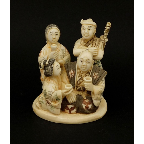 531 - Japanese carved ivory okimono of four figures drinking, character marks to the base, 6cm high