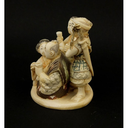 531 - Japanese carved ivory okimono of four figures drinking, character marks to the base, 6cm high