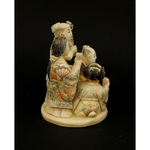 531 - Japanese carved ivory okimono of four figures drinking, character marks to the base, 6cm high