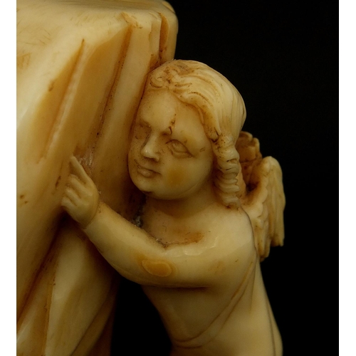 3 - Ivory carving of a Putti hiding behind a curtain, 7.2cm high