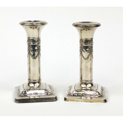 843 - Pair of silver column candlesticks embossed with swags, Henry Matthews Birmingham 1906, 13cm high, a... 