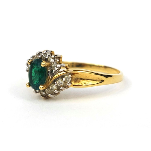 1016 - 18ct gold emerald and diamond crossover ring, set with a central emerald and fourteen diamonds, size... 