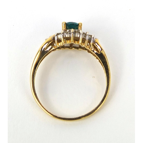 1016 - 18ct gold emerald and diamond crossover ring, set with a central emerald and fourteen diamonds, size... 