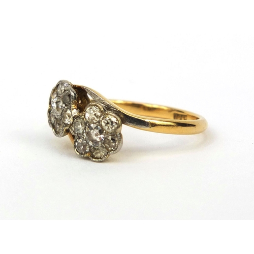 1001 - 18ct gold diamond double flower head crossover ring, set with fourteen diamonds, size L, approximate... 