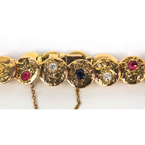 916 - Designer unmarked gold bracelet set with diamonds, ruby's and a sapphire, 18cm long, approximate wei... 