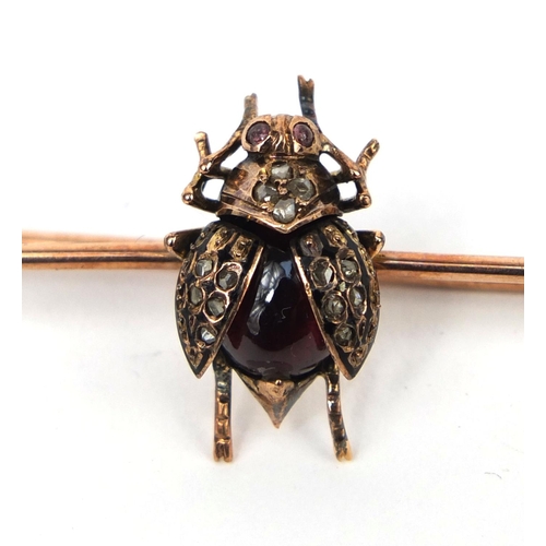 938 - 9ct gold insect bar brooch with a cabochon garnet body and diamonds to the wings, 5.2cm long, approx... 