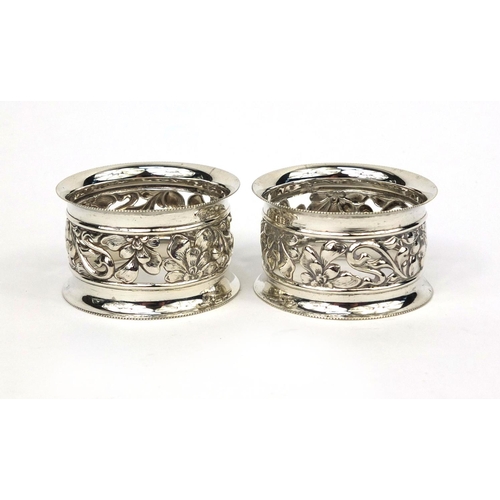 878 - Pair of circular silver napkin rings with floral pierced decoration, GEW Birmingham 1906, 5cm in dia... 