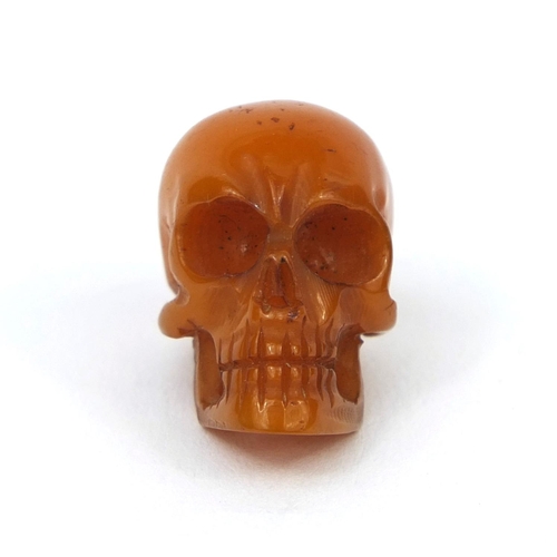 144 - Miniature butterscotch amber coloured carving of a skull, 2.3cm high