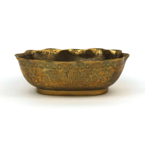 558 - Chinese bronze bowl with shaped edge, engraved with dragons chasing the flaming pearl, character mar... 