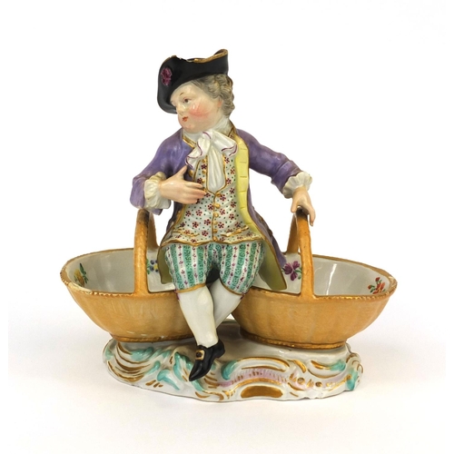 666 - Meissen hand painted porcelain double salt, in the form of a young man sat on two baskets, cross swo... 