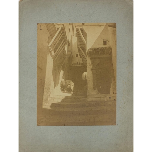 193 - Four Middle Eastern black and white photographs, one of a figure on a stairway, another with figures... 