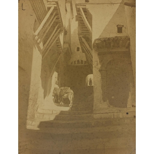 193 - Four Middle Eastern black and white photographs, one of a figure on a stairway, another with figures... 