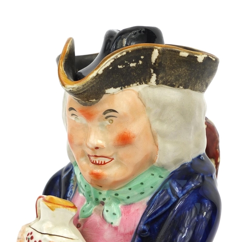 708 - 19th century Staffordshire pottery Toby jug, wearing a blue jacket holding a jug, 21.5cm high