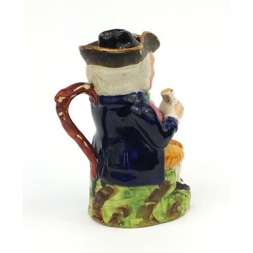 708 - 19th century Staffordshire pottery Toby jug, wearing a blue jacket holding a jug, 21.5cm high