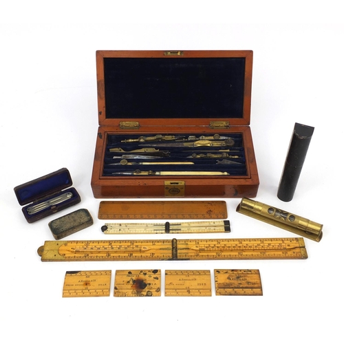 64 - Drawing instruments including a folding ivory ruler and a J Hicks of London war department mahogany ... 