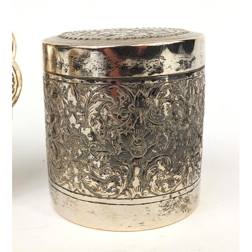 602 - Indian unmarked silver cylindrical box and cover, together with a pin dish, both embossed with flowe... 