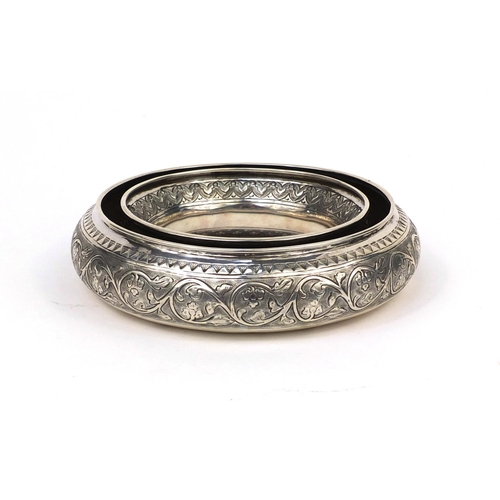 603 - Circular Middle Eastern unmarked silver holder embossed with floral motifs, 16.5cm in diameter, appr... 