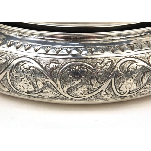 603 - Circular Middle Eastern unmarked silver holder embossed with floral motifs, 16.5cm in diameter, appr... 