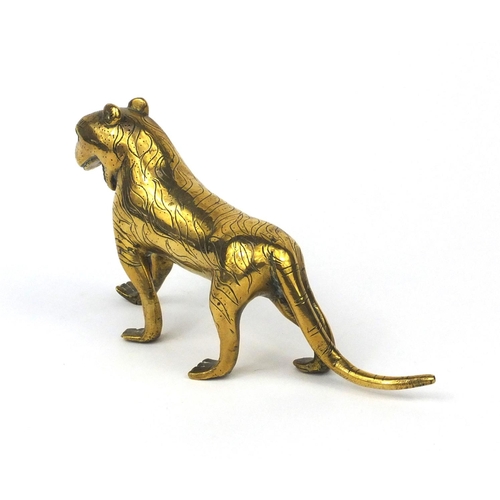 633 - Antique Middle Eastern brass study of a tiger set with a red stone eye, 22cm in length