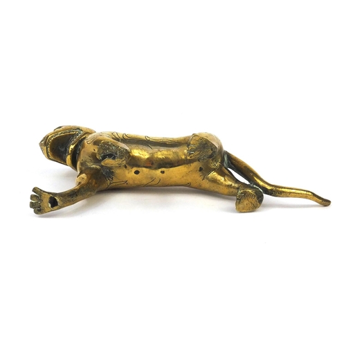 633 - Antique Middle Eastern brass study of a tiger set with a red stone eye, 22cm in length