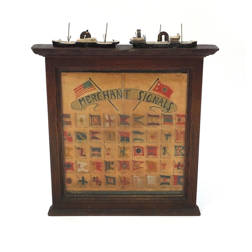 386 - Oak framed display of hand painted Merchant signals, mounted with two ships, 31cm x 30cm excluding t... 