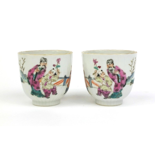 472 - Pair of Chinese porcelain tea cups painted in the famille rose palette with court figures playing, f... 