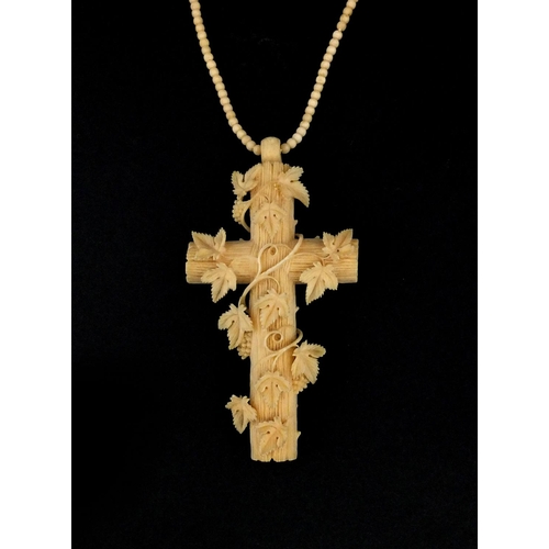 1023 - Victorian ivory cross pendant carved with vines, on a bead necklace, the pendant 9.5cm long, approxi... 