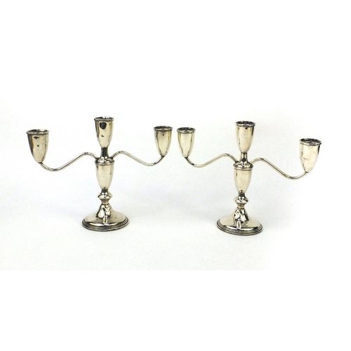 854 - Pair of sterling silver three branch candelabrum, each impressed 'Sterling' to the base, 20.5cm high