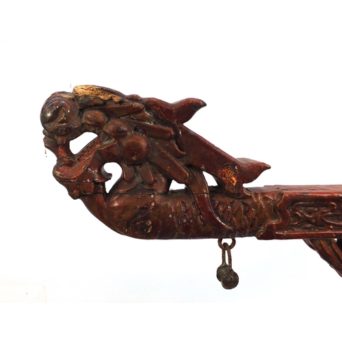 547 - Chinese red lacquered wooden shop hanging, carved with clouse and a dragon, 131cm high