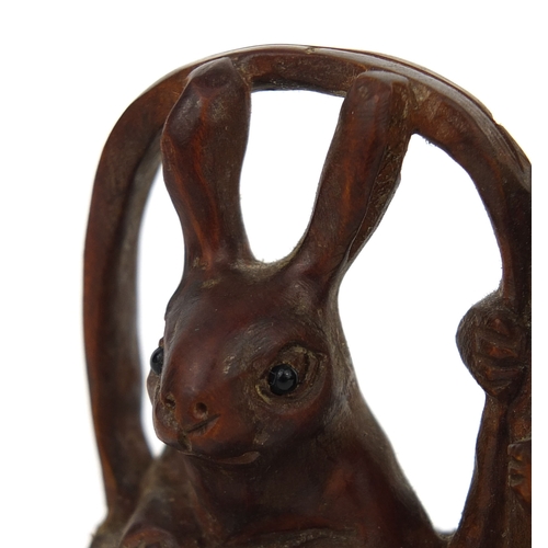 538 - Japanese carved boxwood Netsuke in the form of two rabbits, one in a basket, character to one leg, 5... 