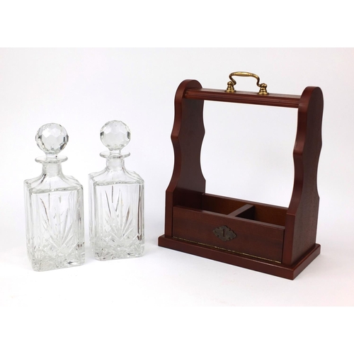 2200 - Mahogany two bottle Tantalus with decanters and brass carrying handle, 33cm high