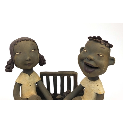 2358 - Two comical Chinese terracotta figure groups  one of two lovers sitting at a dinner table and one of... 